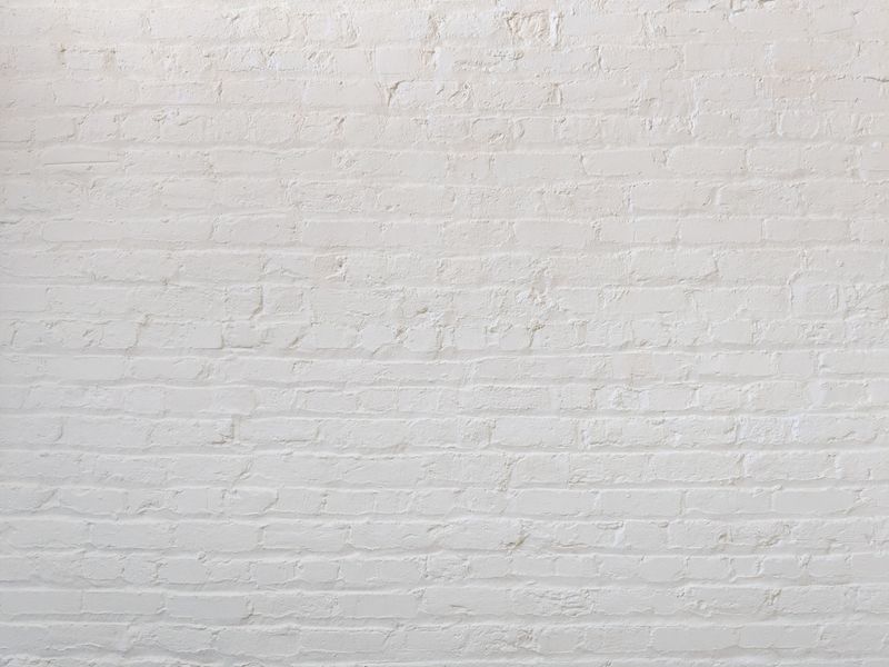 Wit geschilderde bakstenen muur