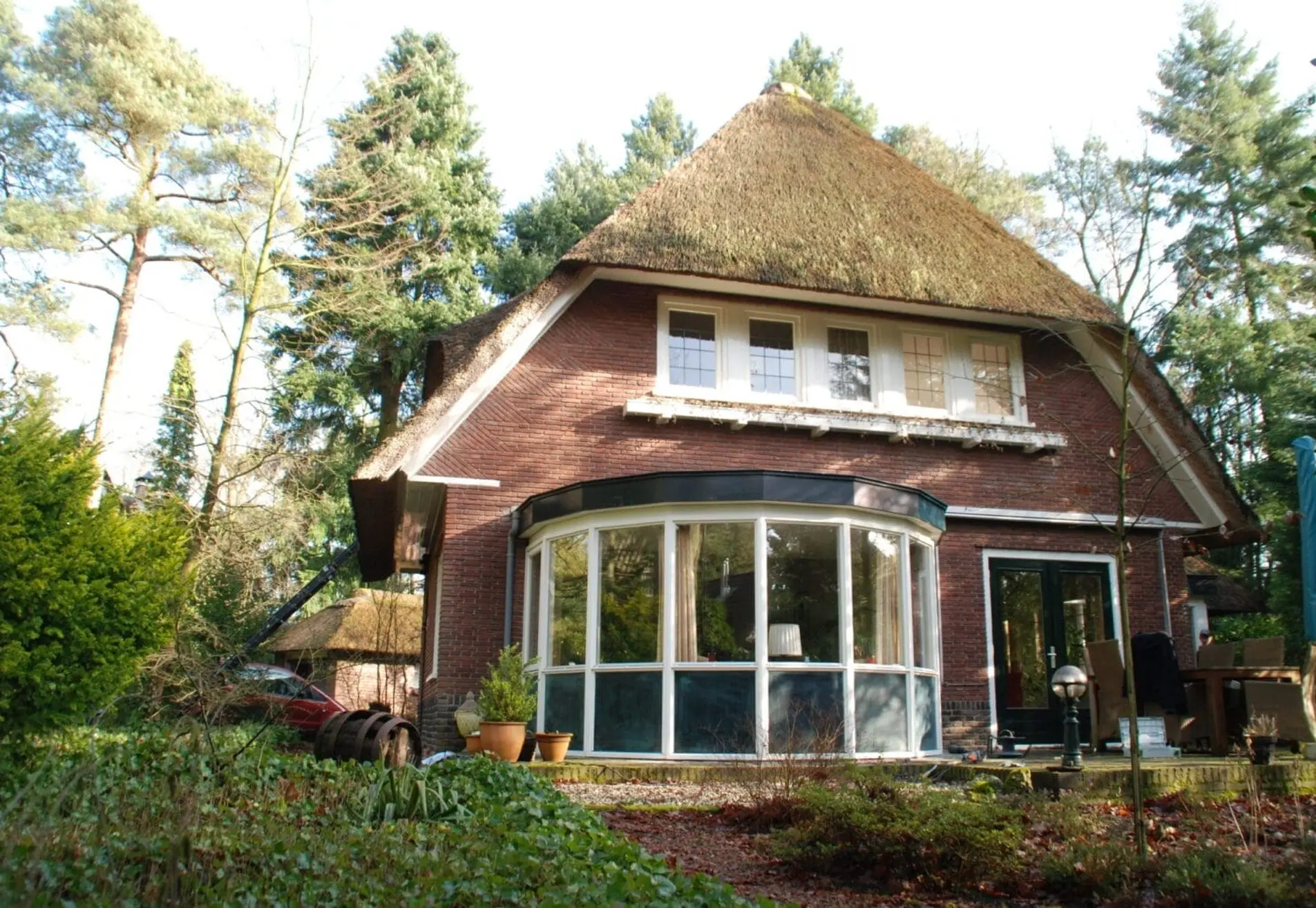 Villa in bosrijke omgeving met een rieten dak volledig geschilderd.