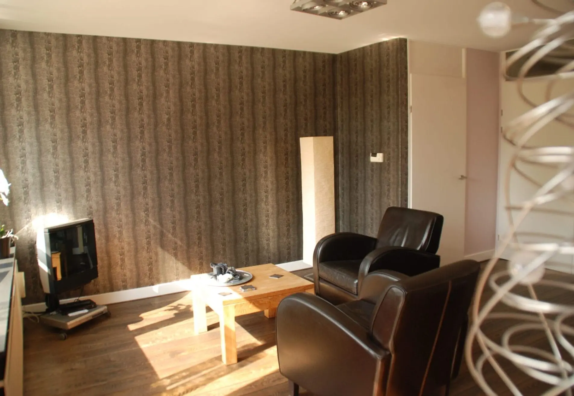 Nieuw behang met slangenpatroon aangebracht op de muur en de rest van de kamer geschilderd.